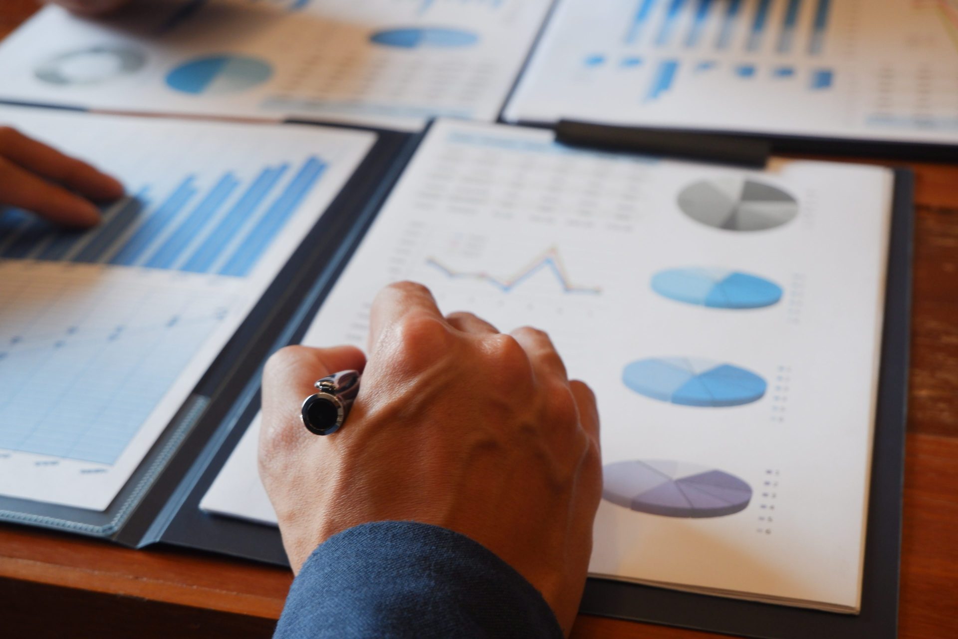 Man evaluating printed data charts with pen in hand.