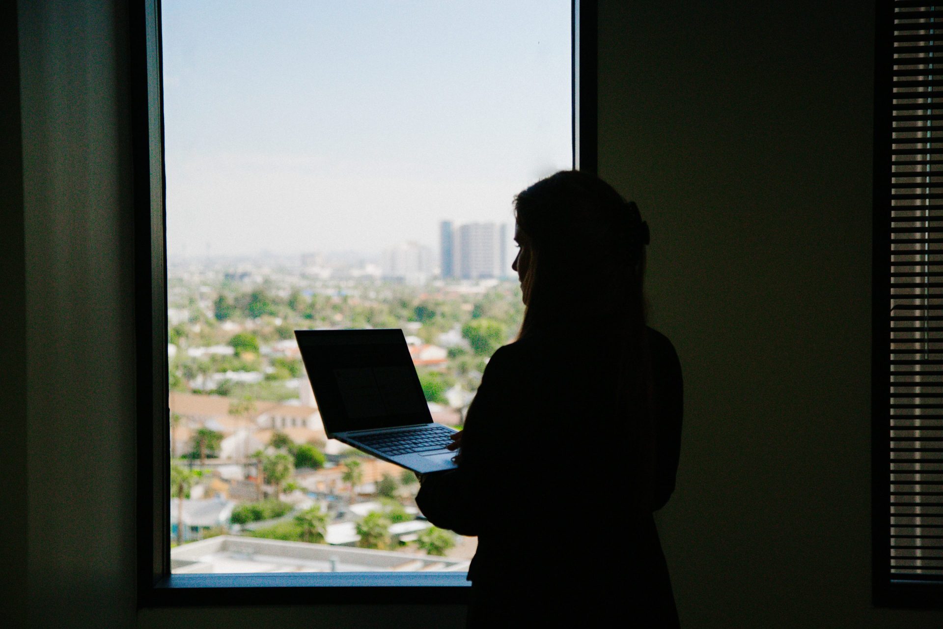 Women looking out window with her laptop