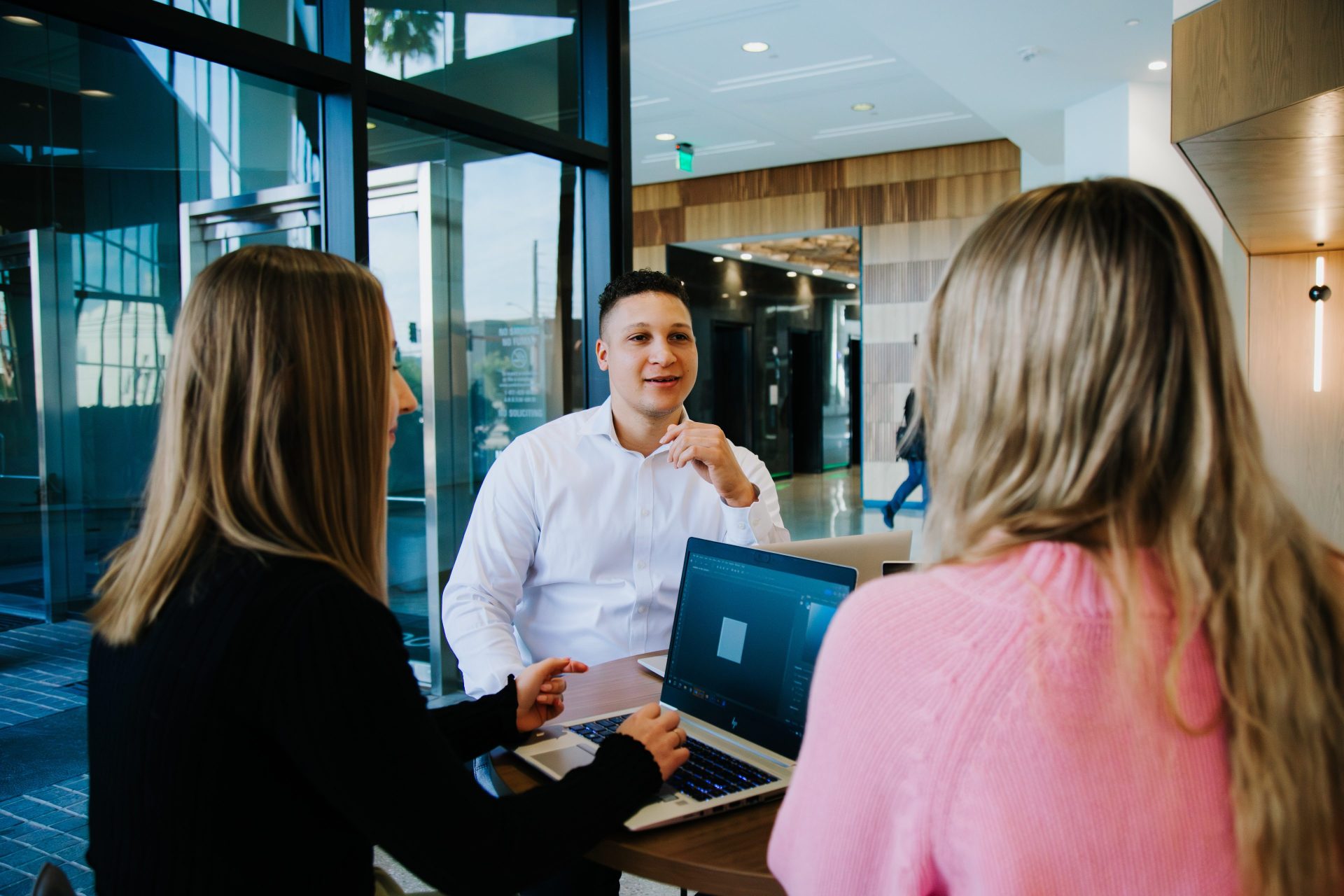 Business people sitting at a table in an open office environment working together on their computers