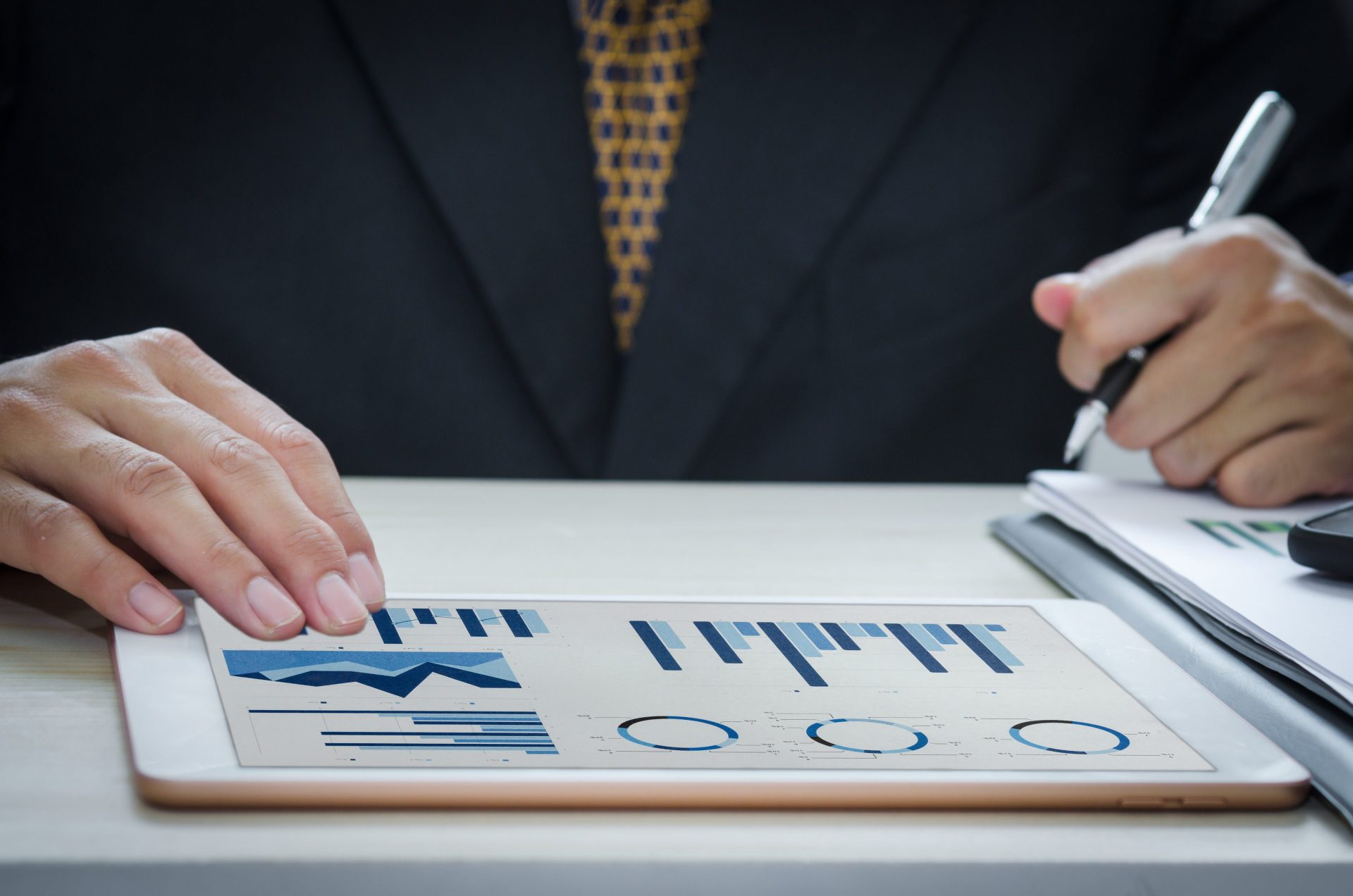 Business man report graphs and charts of financial statements and profit growth with tablet.